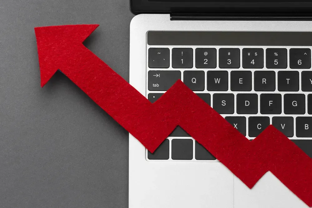 Photo of part of a laptop and a graphic of a red arrow as data growth.